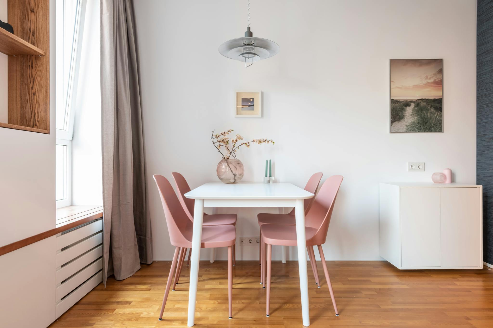 Comfortable room with contemporary interior with picture on wall and vase with plant on table in daytime